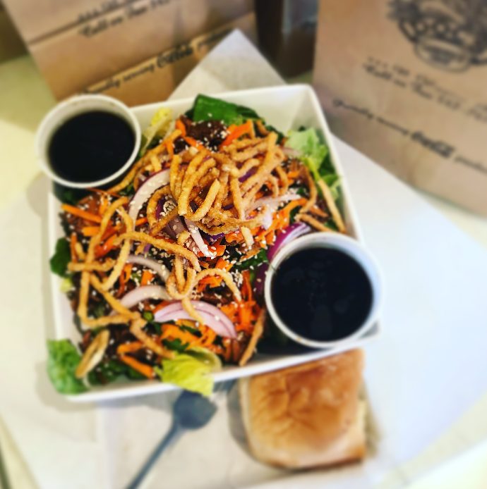Teriyaki sesame chicken salad with crispy noodles and dressing on the side